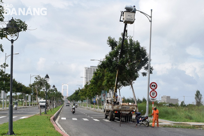 Công nhân của Công ty Quản lý vận hành điện chiếu sáng công cộng Đà Nẵng sửa chữa đèn chiếu sáng tại đường Lê Đức Thọ.