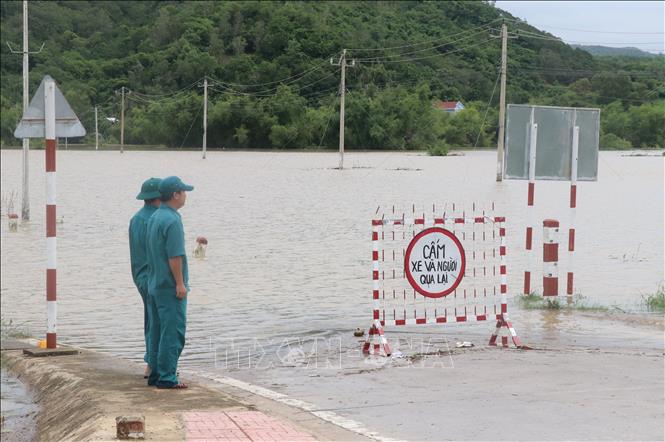 Lực lượng chức năng trực chốt tại khu vực cấm người dân qua tuyến đường DT642 thị trấn La Hai, huyện Đồng Xuân (Phú Yên) bị ngập do nước lũ trong cơn bão số 5 vừa qua. Ảnh: Phạm Cường/TTXVN