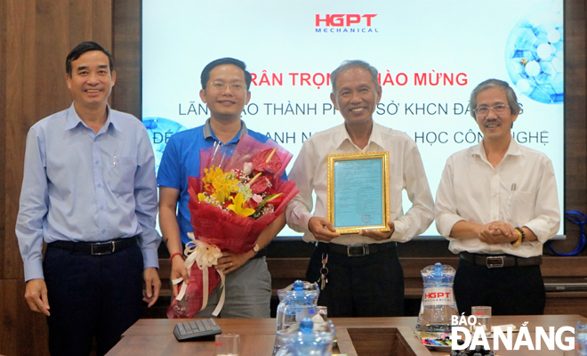 Phó Chủ tịch UBND thành phố Lê Trung Chinh (trái) chúc mừng Công ty CP Cơ khí Hà Giang Phước Tường được trao chứng nhận doanh nghiệp KH&CN. Ảnh: K.NINH