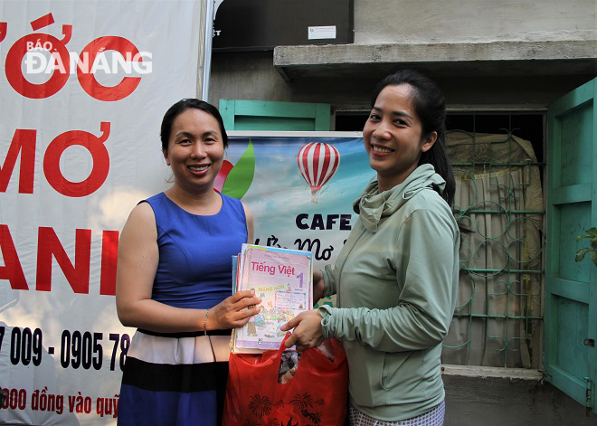 Mrs Huyen (left) receiving used books and clothes from a philanthropist