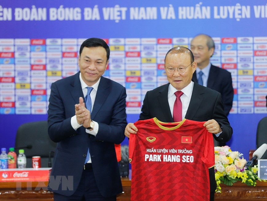 Phó Chủ tịch VFF Trần Quốc Tuấn trao áo đấu của đội tuyển bóng đá quốc gia Việt Nam cho HLV Park Hang-seo sau khi ký gia hạn hợp đồng. (Ảnh: Trọng Đạt/TTXVN)