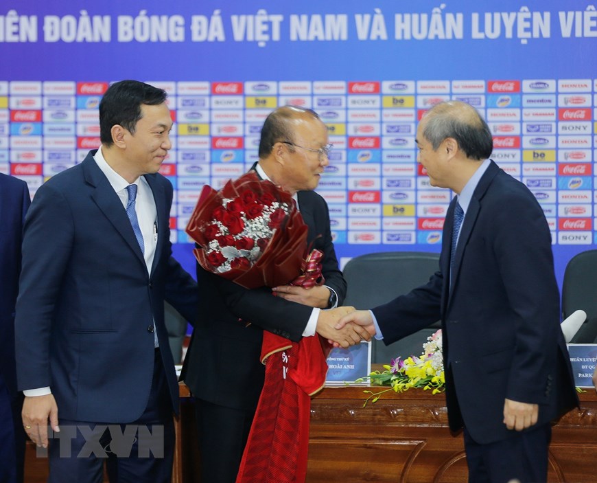 Tổng cục trưởng Tổng cục Thể dục Thể thao Vương Bích Thắng chúc mừng huấn luyện viên Park Hang-seo sau khi ký gia hạn hợp đồng với VFF. (Ảnh: Trọng Đạt/TTXVN)
