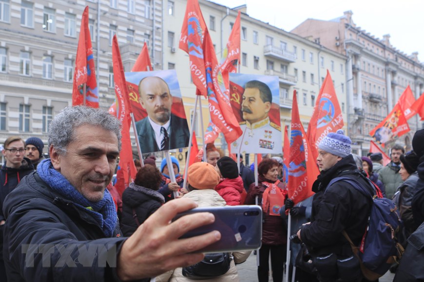 Người dân Moskva thích thú ghi lại hình ảnh đoàn người tuần hành qua các tuyến phố. (Ảnh: Trần Hiếu/TTXVN)