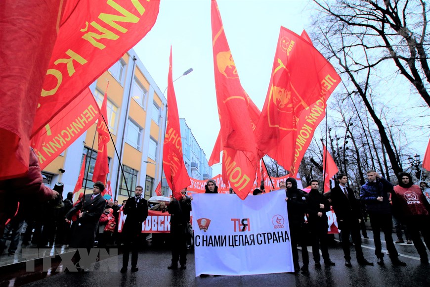 Các thành viên Đoàn thanh niên cộng sản toàn Nga mang tên Lenin tham gia tuần hành kỷ niệm lần thứ 102 Cách mạng tháng Mười Nga vĩ đại. Ảnh: Trần Hiếu/TTXVN)