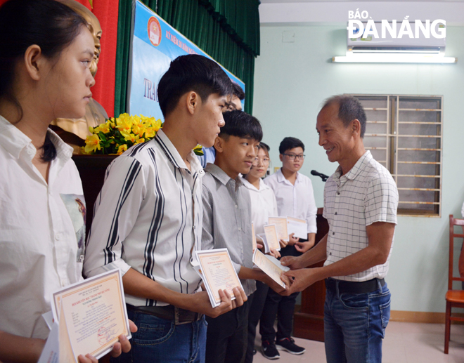 Ông Nguyễn Thành Lân (phải) trao học bổng sinh viên vượt khó hiếu học.