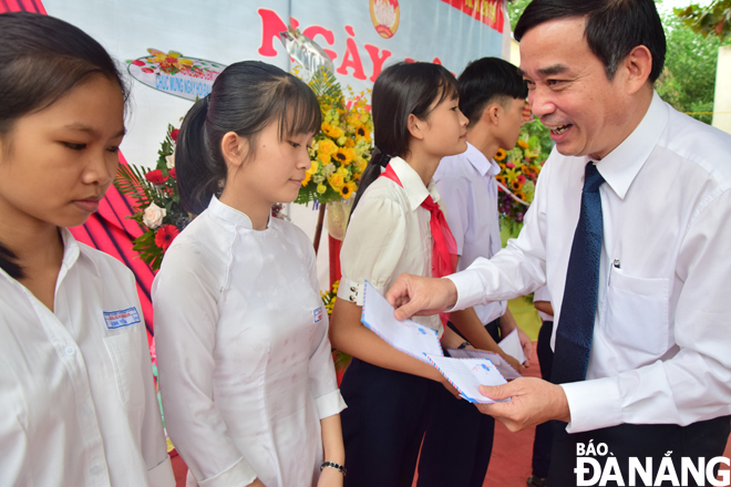 Phó Chủ tịch UBND thành phố Lê Trung Chinh trao quà cho các hộ có thành tích trong xây dựng Nông thôn mới và các em học sinh có thành tích học tập tốt ở thôn Nam Thành. Ảnh: T.HUY