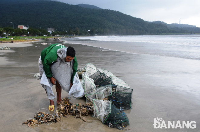 Ngư dân tranh thủ thu lượm lại ngư lưới cụ bị tấp vào bãi biển Bãi Ngang.