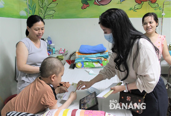 Chị Hà trao tiền hỗ trợ cho các bệnh nhi đang điều trị tại bệnh viện Ung bướu Đà Nẵng.