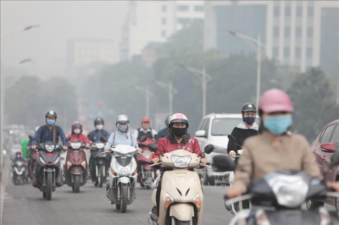 Hiện tượng bụi mịn, sương mù quang học gây ô nhiễm không khí ở Hà Nội người tham gia giao thông hầu như đều phải đeo khẩu trang (ảnh chụp sáng 13-11-2019). Ảnh: Thành Đạt/TTXVN