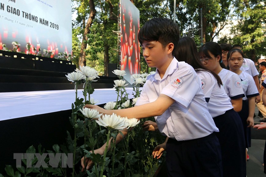 Đông đảo thanh thiếu niên Thành phố Hồ Chí Minh đặt hoa tưởng niệm các nạn nhân tử vong do tai nạn giao thông. (Ảnh: Thanh Vũ/TTXVN)
