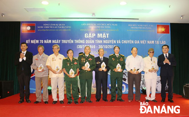 The Vice Chairman of the municipal People's Committee cum Chairman of the Viet Nam-Laos Friendship Association in the city, Mr Ho Ky Minh, (1st from left) honouring Vietnamese voluntary soldiers and experts who once served in Laos