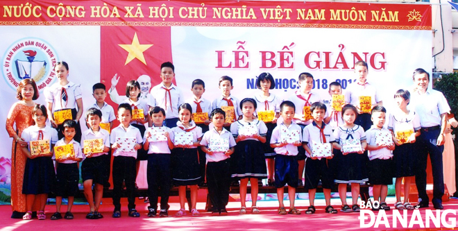 Cô Trần Thị Kim Bình (bìa trái) khen thưởng cho các em học sinh trong năm học 2018-2019.     Ảnh: NGỌC PHÚ