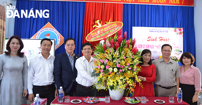 Chủ tịch HĐND thành phố Nguyễn Nho Trung tặng hoa chúc mừng tập thể sư phạm Trường TH Triệu Thị Trinh.