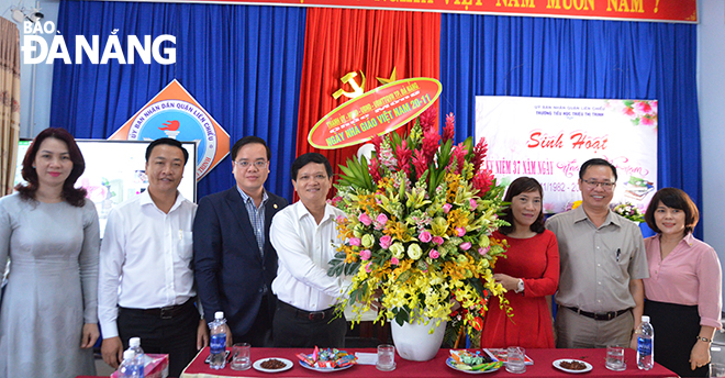 Chairman Trung (4th left) presenting flowers to representatives from the Trieu Thi Trinh school on their special day