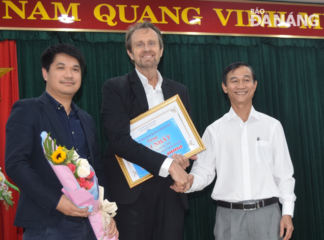 Chairman of Thanh Khe District People’s Committee Nguyen Van Tinh (right) presenting the first prize and the community-selected award to Singapore-based studioMilou architecture firm at the awards ceremony for the contest on Thursday morning