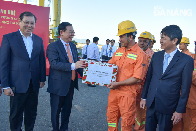 Deputy Prime Minister Vuong Dinh Hue (2nd from left) presenting Tet gifts to the port’s staff members