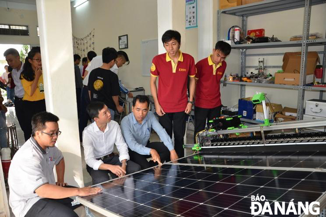 A group of students from the Da Nang University of Science and Technology introducing a solar panel cleaning robot to some experts 