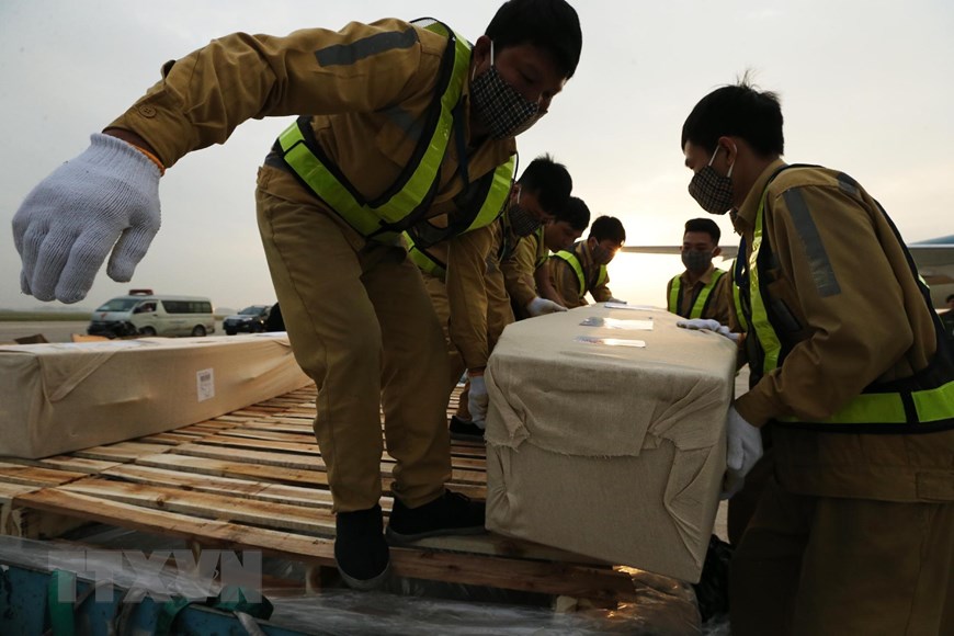 Nhân viên sân bay quốc tế Nội Bài vận chuyển thi thể các nạn nhân lên ôtô để đưa về quê nhà. (Ảnh: Lâm Khánh/TTXVN)
