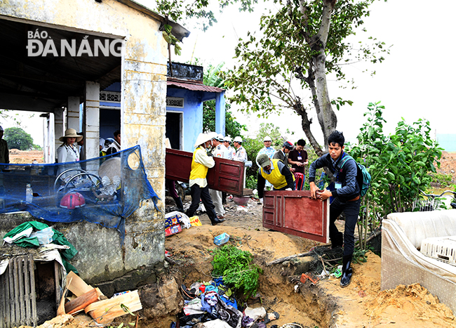 Ban thực hiện cưỡng chế quận Cẩm Lệ hỗ trợ nhân công, phương tiện giúp các hộ dân di dời tài sản, vật kiến trúc. Ảnh: ĐẶNG NỞ