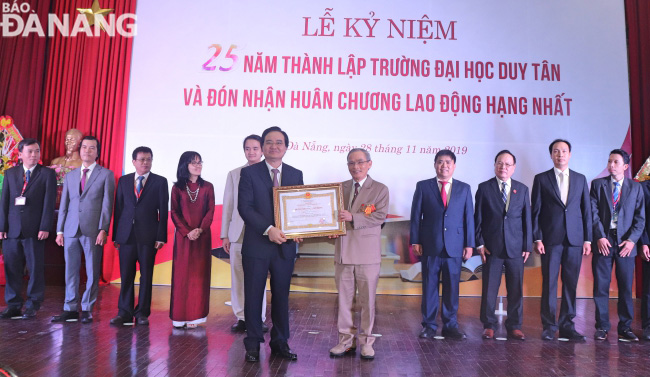 Minister of Education and Training Phung Xuan Nha (left) awarding a First-class Labour Medal to a Duy Tan University representative