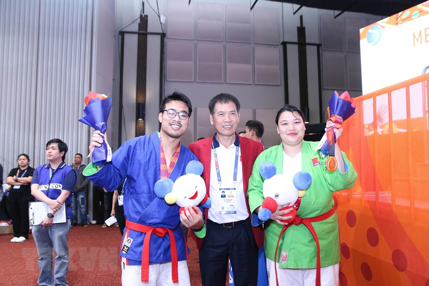 Trưởng đoàn thể thao Việt Nam Trần Đức Phấn chúc mừng các vận động viên. (Ảnh: Hoàng Linh/TTXVN)