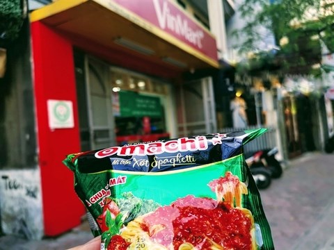 A pack of Omachi-branded noodles made by Masan Consumer, in front of a Vinmart convenient store run by VinCommerce. VinCommerce, VinEco and Masan Consumer will officially merge to create the leading group of retail and consumer goods in Vietnam. (Photo: cafef.vn)