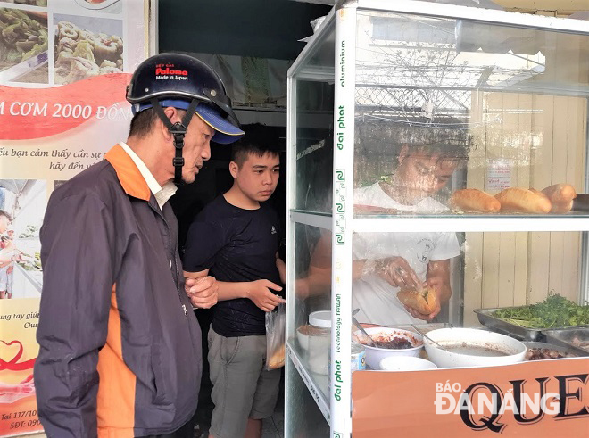 Vinh’s charity bread stall is a popular place for 'xe om' (motorbike taxi) drivers, lottery ticket sellers, and delivery employees.