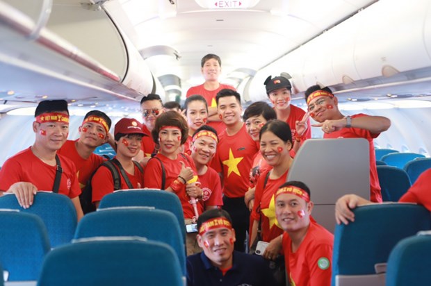 Cổ động viên Việt Nam trên chuyến bay của hãng hàng không Vietnam Airlines. (Ảnh: CTV/Vietnam+)