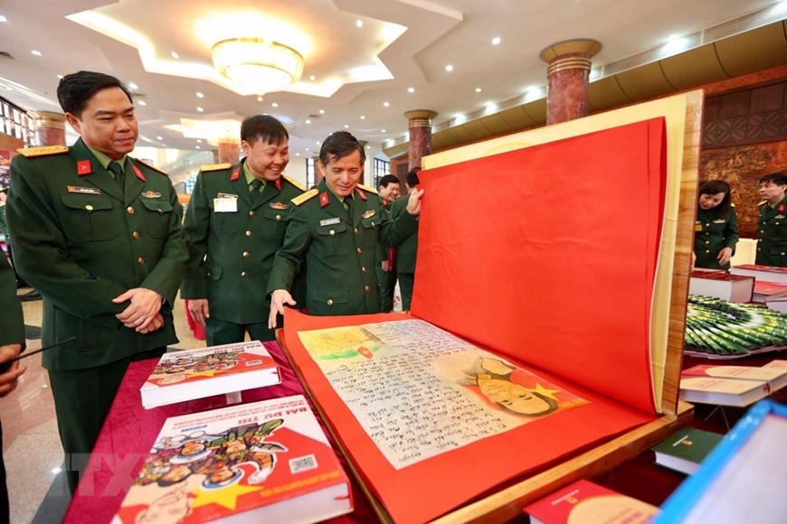 Các đại biểu tham quan trưng bày bài dự thi tìm hiểu 30 năm Ngày hội Quốc phòng toàn dân và 75 năm Ngày thành lập Quân đội nhân dân Việt Nam. (Ảnh: Dương Giang/TTXVN)