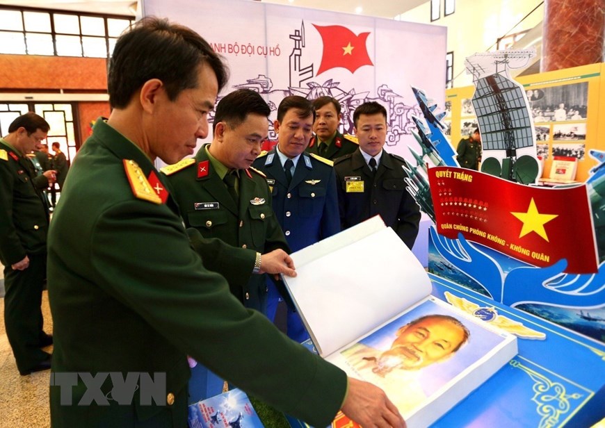 Các đại biểu tham quan trưng bày bài dự thi tìm hiểu 30 năm Ngày hội Quốc phòng toàn dân và 75 năm Ngày thành lập Quân đội nhân dân Việt Nam. (Ảnh: Dương Giang/TTXVN)