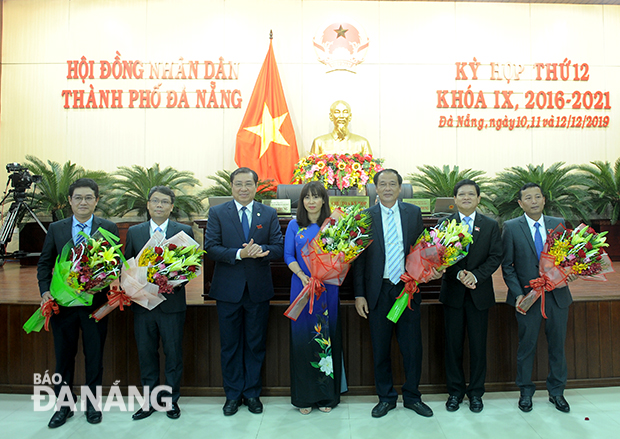 Chủ tịch HĐND thành phố Nguyễn Nho Trung (thứ 2 bìa phải sang) và Chủ tịch UBND thành phố Huỳnh Đức Thơ (thứ 3 từ trái sang) tặng hoa cho các đại biểu