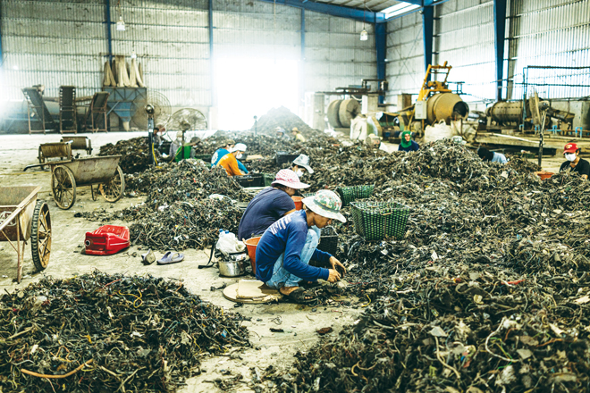 Những người lao động nước ngoài đang phân loại rác thải ở nhà máy New Sky Mental.