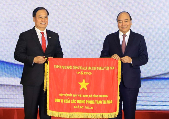 Thủ tướng Chính phủ Nguyễn Xuân Phúc trao Cờ thi đua của Chính phủ tặng Hiệp hội Dệt may Việt Nam. Ảnh: TTXVN