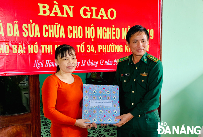 Đại diện chỉ huy Đồn Biên phòng Non Nước tặng quà cho bà Hồ Thị Nga. 