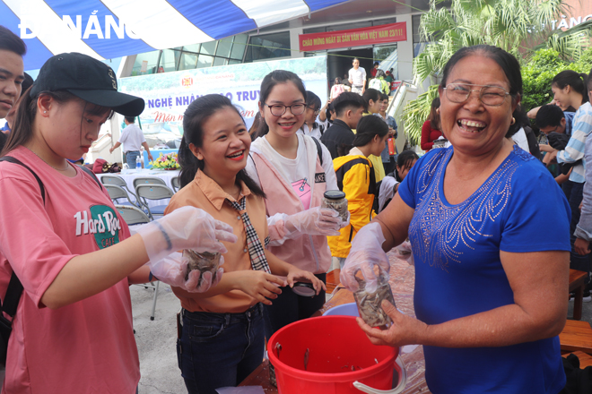 An artisan from the Nam O fish sauce making village is seen enjoying fun moments whilst instructing local students how to make fish sauce