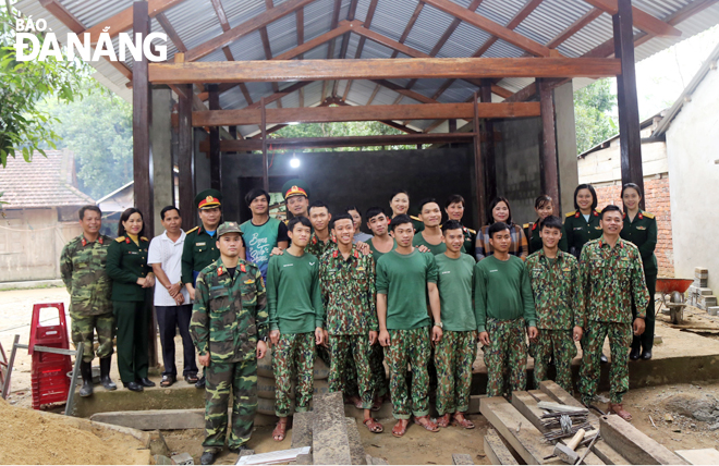 Đoàn công tác Lữ đoàn Thông tin 575 chụp ảnh lưu niệm trước công trình sửa chữa nhà anh Blup Trới, ở thôn Glêê, xã Tà Bhing, huyện Nam Giang.