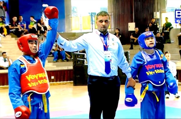 Tran Anh Tuan (left) is announced winner of the World Vovinam Championship's men's 54kg class. (Source: baothanhoa.vn)