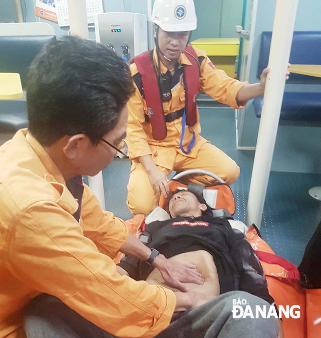 Các bác sĩ sơ cứu cho ngư dân trước khi đưa về đất liền cấp cứu.