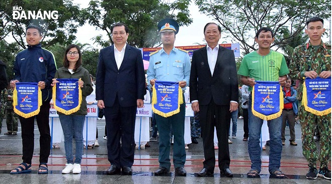 Chủ tịch UBND thành phố Huỳnh Đức Thơ (thứ 3, trái sang) và Phó Chủ tịch Hội Nhà báo Việt Nam Mai Đức Lộc (thứ 5, trái sang) chụp ảnh kỷ niệm cùng các đoàn VĐV.
