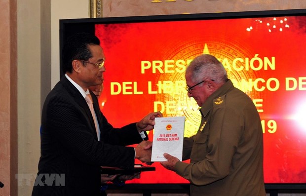 Vietnamese Ambassador to Cuba Nguyen Trung Thanh (L) hands over Vietnam Defence White Paper 2019 to Chief of the General Staff of Cuba Álvaro López Miera (Photo: VNA) 