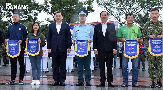 Chairman Tho (3rd left) and Vice Chairman of the Viet Nam Journalists’ Association Mai Duc Loc (5th left) taking a souvenir photo with representatives from the groups of participating runners