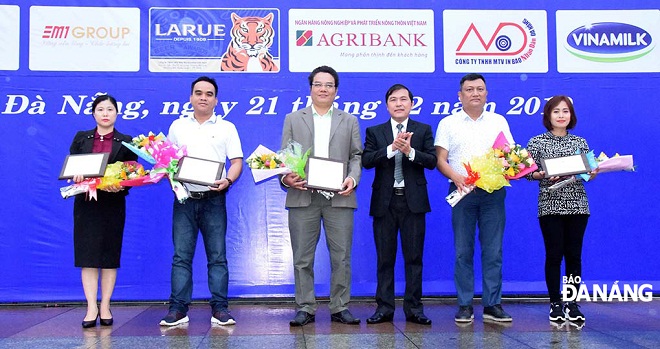 DA NANG Newspaper Editor-in-chief cum Head of the competition’s organisers Nguyen Duc Nam (3rd, right) presenting flowers and medals to sponsors