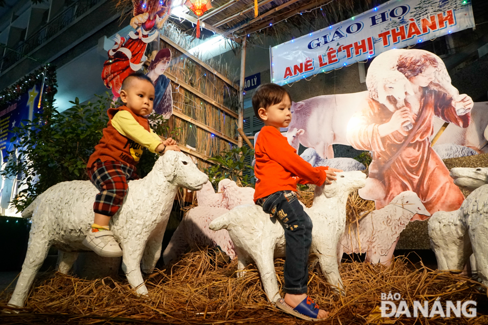 Children taking souvenir photos at a carefully-decorated Christmas site