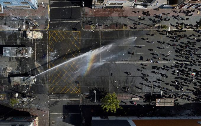 Cảnh sát phun vòi rồng vào những người biểu tình phản đối chính phủ tăng giá vé phương tiện công cộng ở Valparaiso, Chile ngày 26/10. Ảnh: Matias Delacroix/AP