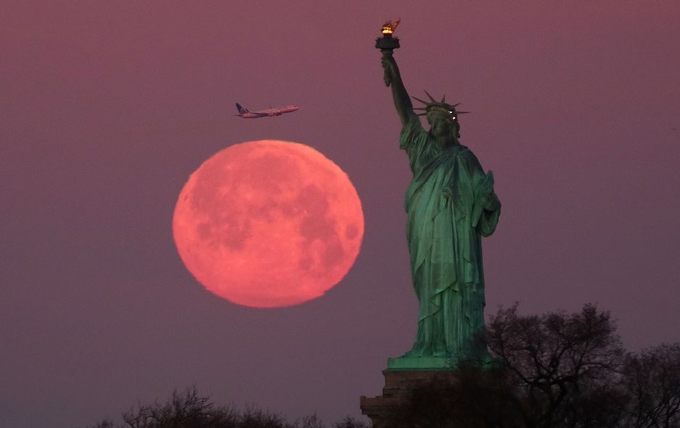 Siêu trăng nhìn từ Tượng Nữ thần Tự do vào bình minh ngày 19/2 ở thành phố New York, Mỹ. Ảnh: Gary Hershorn/Fox News
