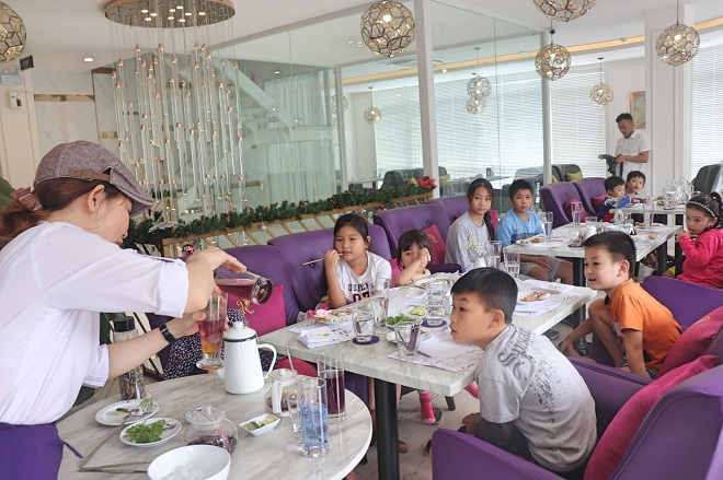 The children are excited by impressive performances of the restaurant's bartender