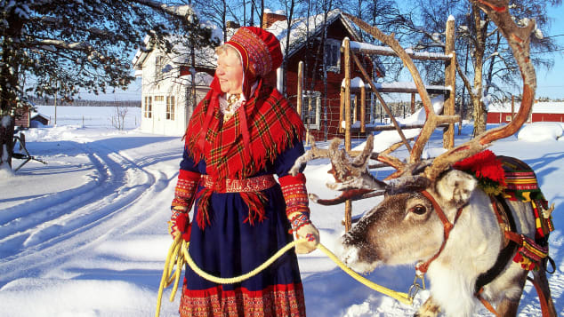 Một người phụ nữ mặc đồ Gákti - trang phục truyền thống của người Sami bản địa- dắt tuần lộc ở Lapland. Ảnh: Visit Finland