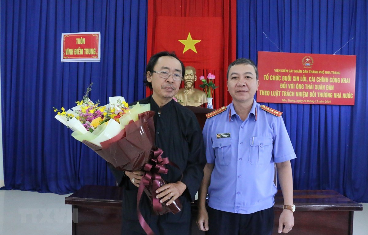 Đại diện Viện Kiểm sát nhân dân thành phố Nha Trang tặng hoa cho ông Thái Xuân Đàn trong buổi xin lỗi sáng 24/12. (Ảnh: Nguyễn Dũng/TTXVN)