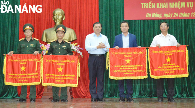 Chủ tịch UBND thành phố Huỳnh Đức Thơ trao cờ thi đua cho các đơn vị dẫn đầu phong trào thi đua năm 2019.  						           Ảnh: NGỌC PHÚ