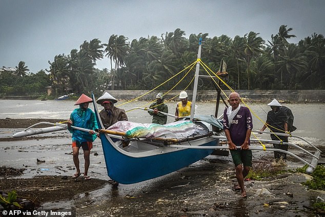 Các ngư dân di chuyển thuyền tới vị trí cao hơn ở vịnh Baybay. Ảnh: AFP.